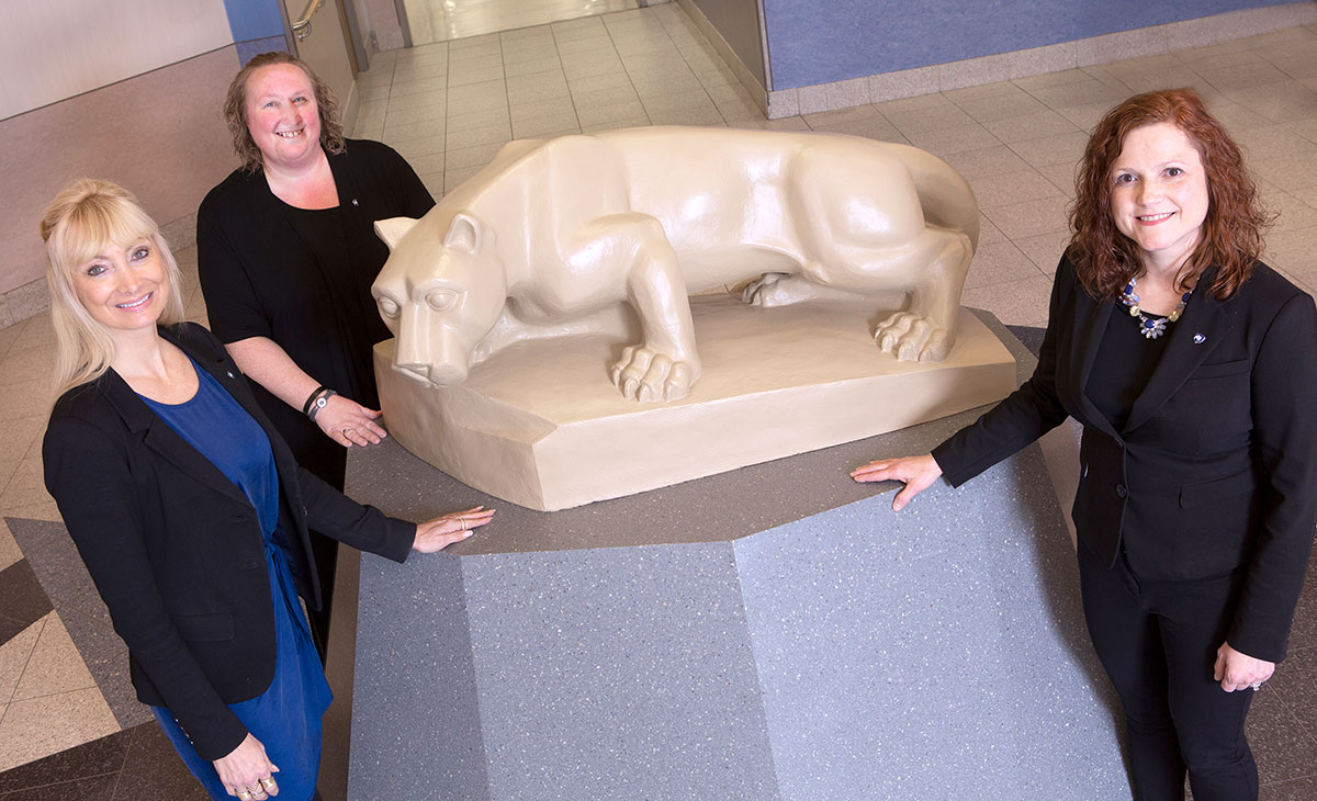 Three members of the Corporate and Foundation Relations team are pictured with the Penn State Nittany Lion statue.