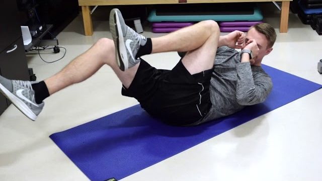 A still from a video shows a person performing the Bicycle Crunches exercise.
