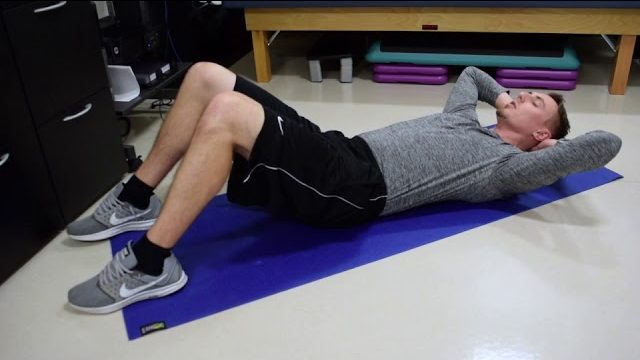 A still from a video shows a person performing the Crunches exercise.