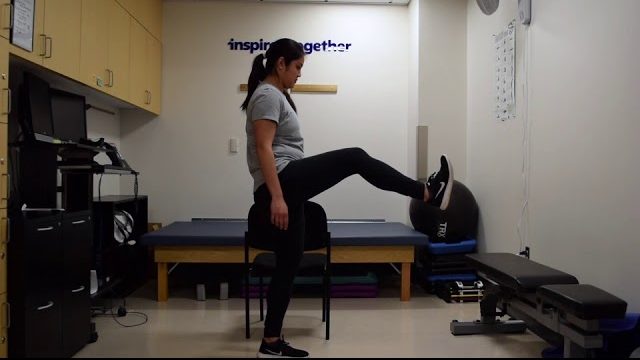 A still from a video shows a person performing the Leg Swings exercise.