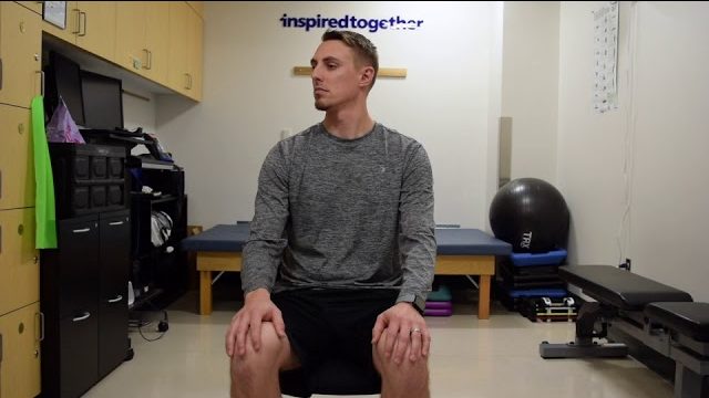 A still from a video shows a person performing the Neck Tilt and Turns exercise.