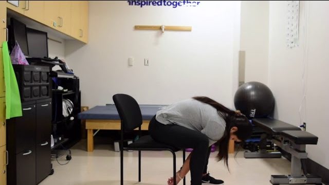 A still from a video shows a person performing the Seated Slump exercise.