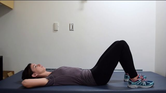A still from a video shows a person performing the Supine Pelvic Tilts exercise.