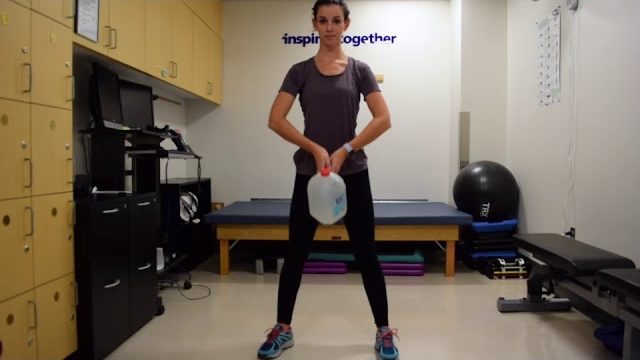 A still from a video shows a person performing the Upright Row exercise.