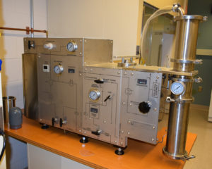 Pictured is the Super Critical CO2 Extractor, a metallic piece of equipment with gauges and a long tube with a gauge at one end.