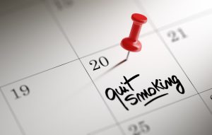 Calendar with push pin in a date with 'quit smoking' written on it